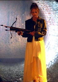 Buffy in the Season One finale "Prophecy Girl", demonstrating the two identities she ahs while holding the masculine weapon juxtaposed against her feminine prom dress.